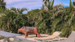 Een zandstrand met een picknicktafel en ligstoelen.