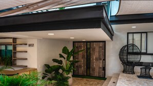 Ein modernes Interieur mit Steinboden, Blumentöpfen und einem schwarzen Metallstuhl.