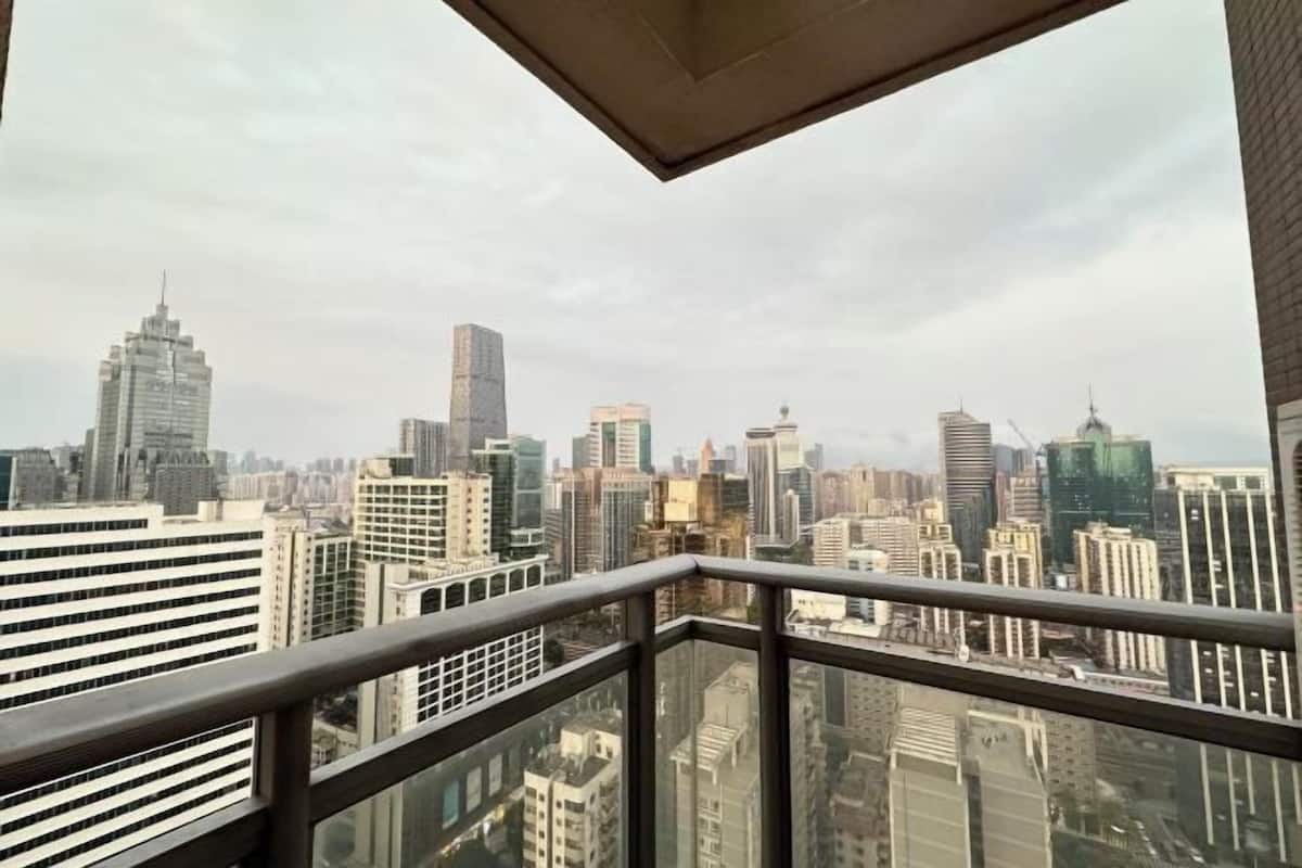 A cityscape view from a high-rise building with a glass balcony.