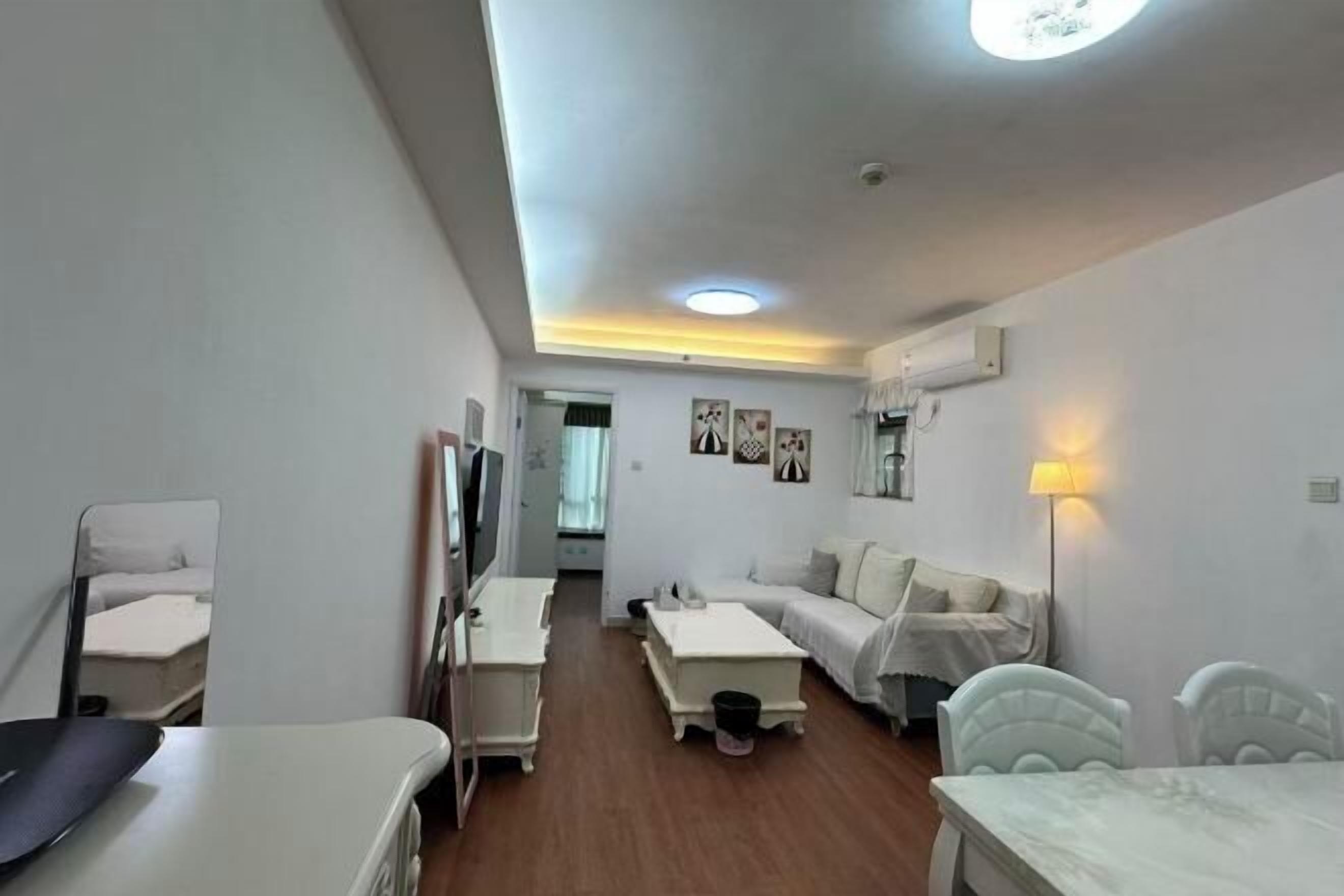 A modern, well-lit room with a bed, a desk, a chair, and a TV.