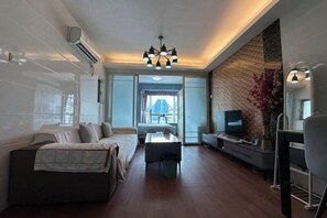 A modern living room with a sofa, a coffee table, a TV, and a large window. - Shenzhen Yage Apartment (Luohu Control Point) (Shenzhen)