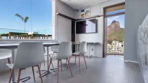 Une chambre moderne dotée d’une grande fenêtre, d’un téléviseur à écran plat et d’un balcon offrant une vue sur la ville.