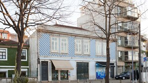 A building with a blue and white facade, a visible storefront, and a parked car. - VIVA  Alameda Suites 3 (Porto)