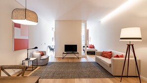 A modern living room with a sofa, a coffee table, a TV, and a lamp.