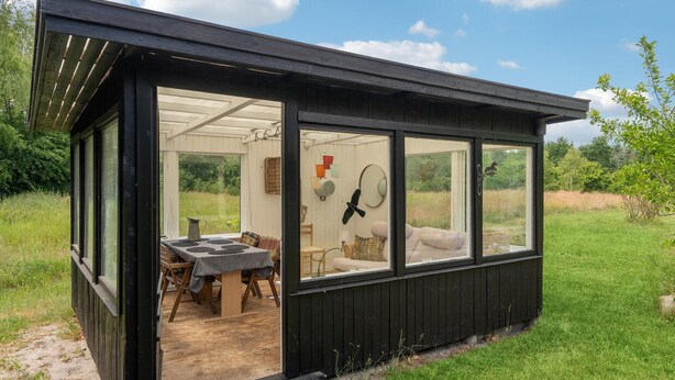 A small wooden cabin with a dining area and a cozy seating space.