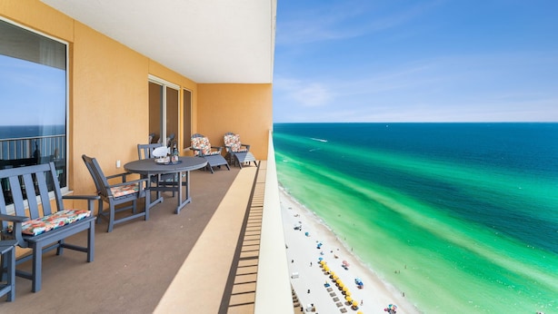 A balcony with a view of a beach and ocean.