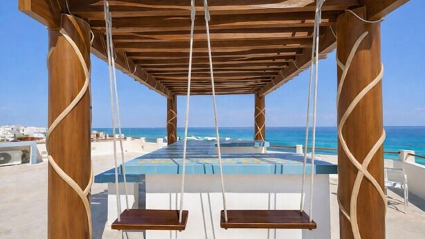 A wooden swing set over a pool with a view of the ocean. - Casa Cielo Studio 2 with detached Bayview Balcony (Isla Mujeres)