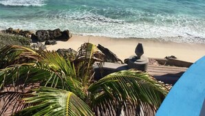 A beach with clear turquoise water, rocks, and palm trees. - Casa Cielo Studio 2 with detached Bayview Balcony (Isla Mujeres)