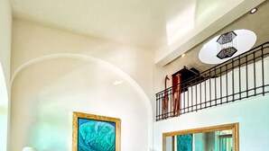 A spacious living room with a large sofa set, a coffee table, and a large mirror.