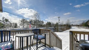 A wooden deck with a table and chairs, overlooking a snowy landscape with trees and a clear sky. - 8 Mi to Cave Run Lake Boating: Outdoor Retreat! (Wellington)