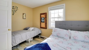 A bedroom with two beds, a ceiling fan, a window with blinds, and a door. - 8 Mi to Cave Run Lake Boating: Outdoor Retreat! (Wellington)