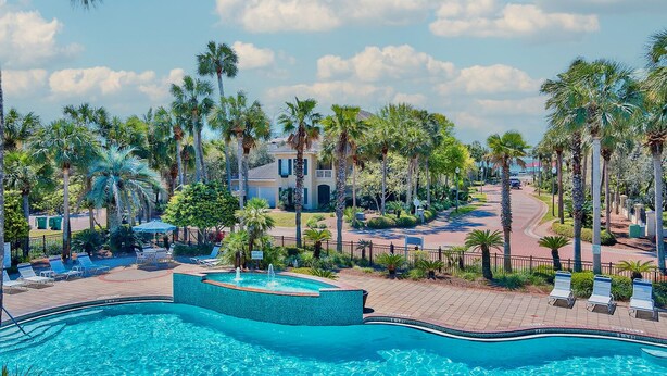 A resort with a swimming pool, palm trees, and a building with a sign that reads "Motel of the Mont". - Million dollar villa · Beachfront neighborhood · Free cruise · Resort amenities (Destin)