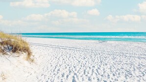 A wide sandy beach with footprints leading to the water, a clear sky, and distant clouds. - Million dollar villa · Beachfront neighborhood · Free cruise · Resort amenities (Destin)