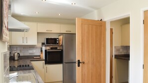 A modern kitchen with stainless steel appliances, wooden flooring, and a wooden door. - 2 bedroom accommodation in Swanwick (Swanwick)