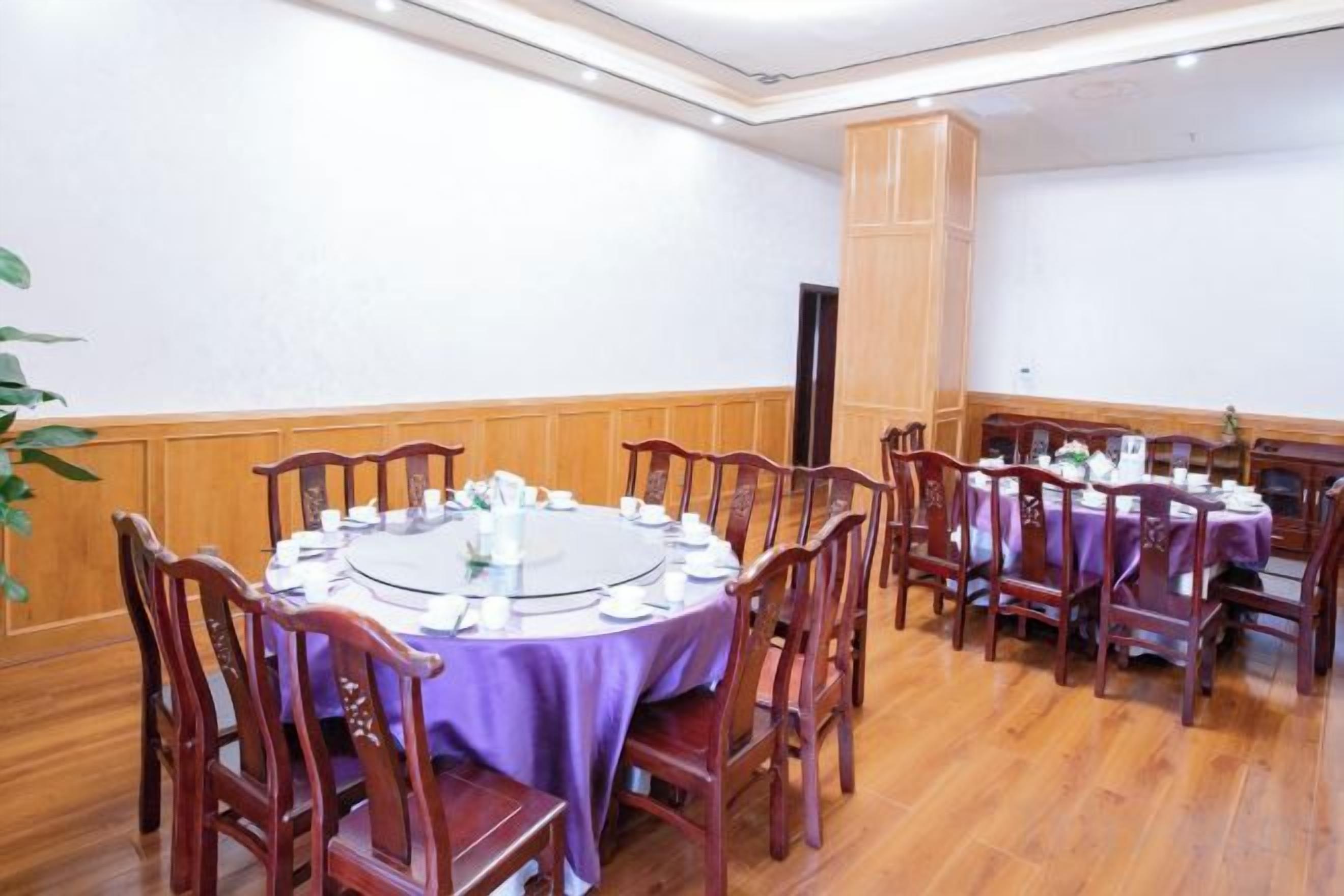 Une salle de conférence avec des tables rondes, des chaises et un plancher en bois.