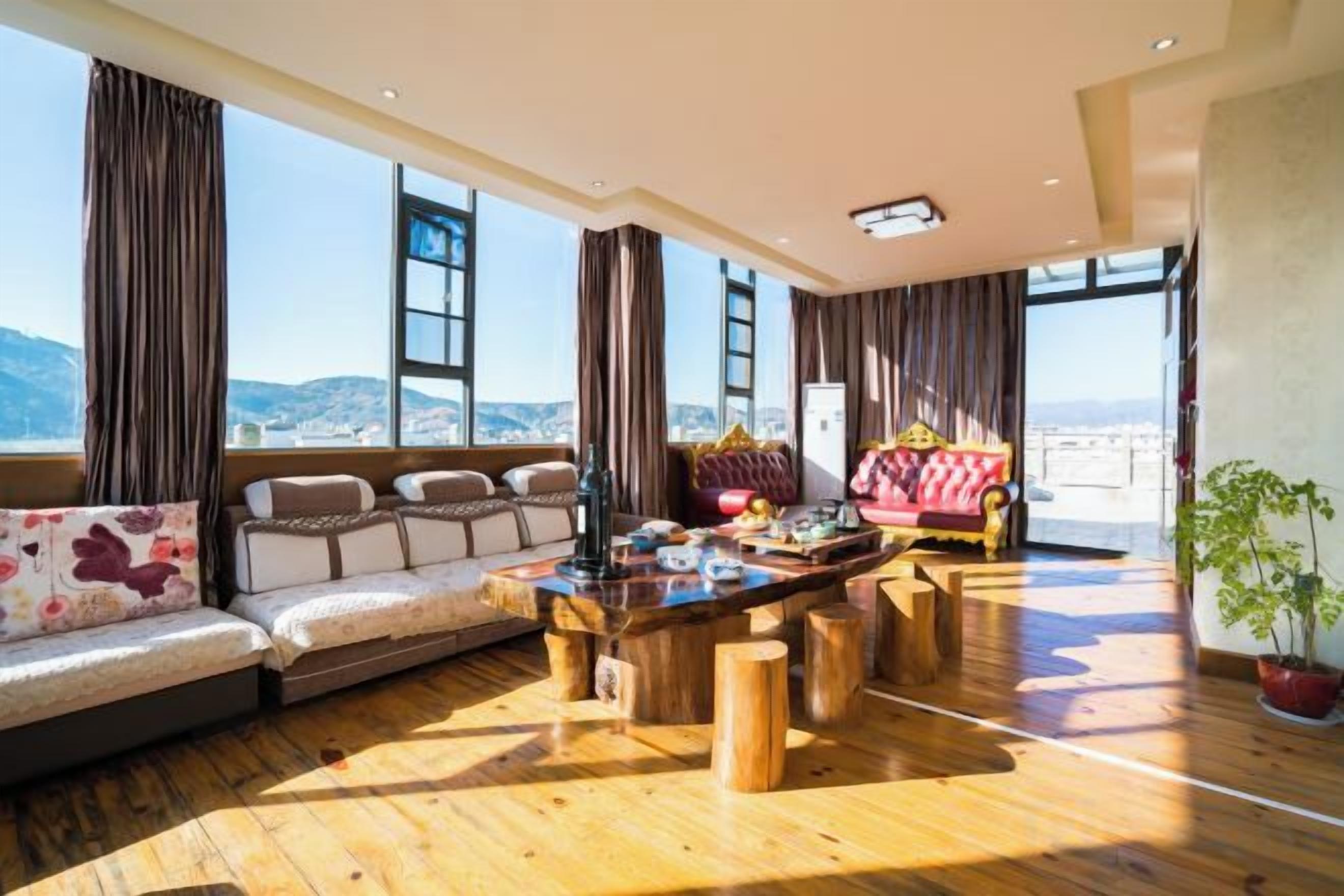 Amplia sala de estar con piso de madera, un juego de sofá, una mesa de centro y vistas a la montaña.