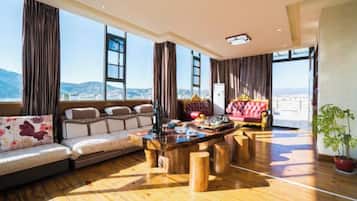 Amplia sala de estar con piso de madera, un juego de sofá, una mesa de centro y vistas a la montaña.
