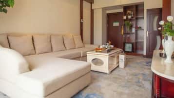 Una sala de estar con un sofá color beige, una mesa de centro y una estantería.