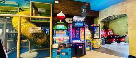 An indoor arcade with various gaming machines, including a pinball machine and a racing game.