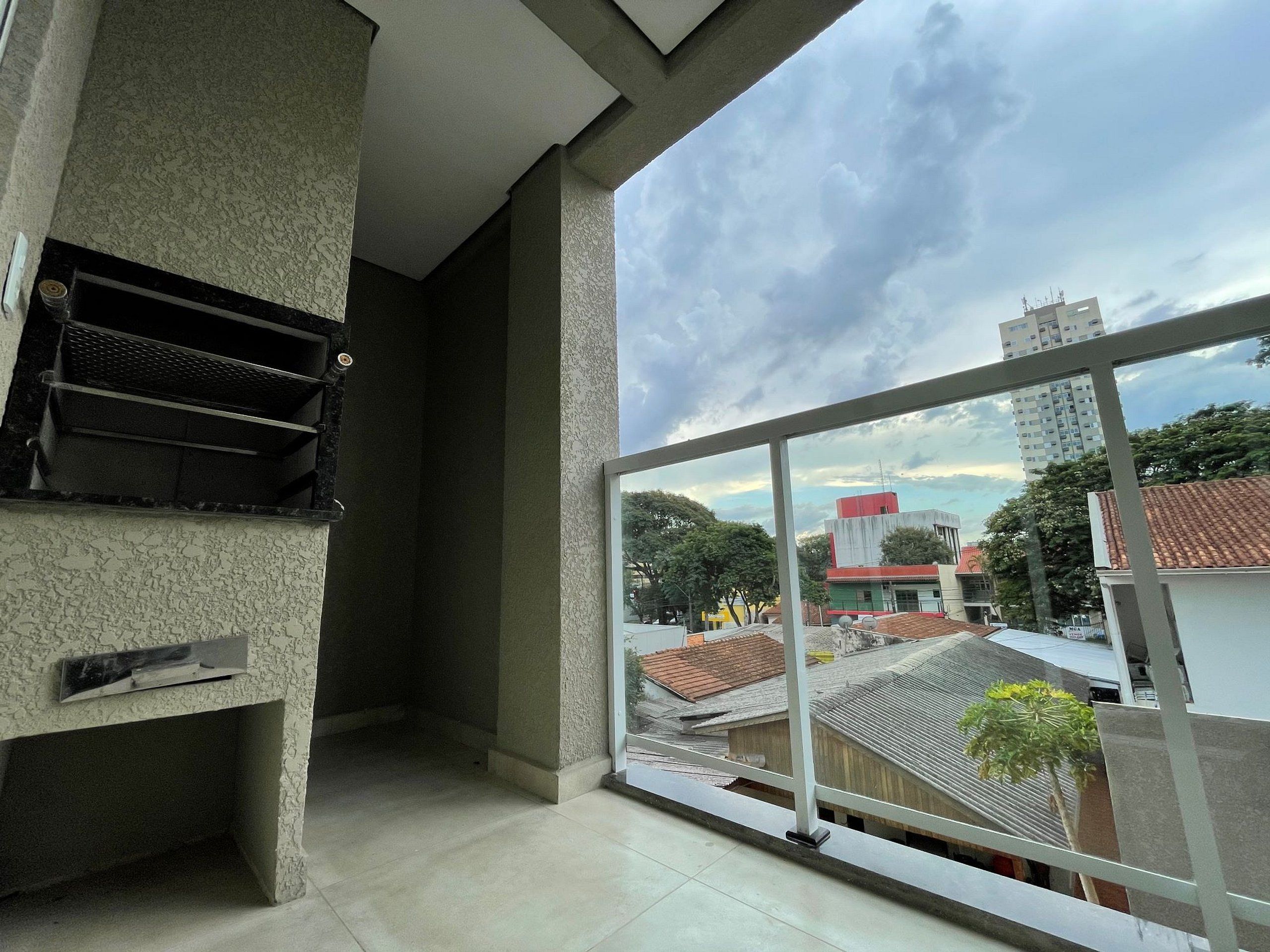 Quarto com uma janela grande, grade de metal e piso de azulejos.