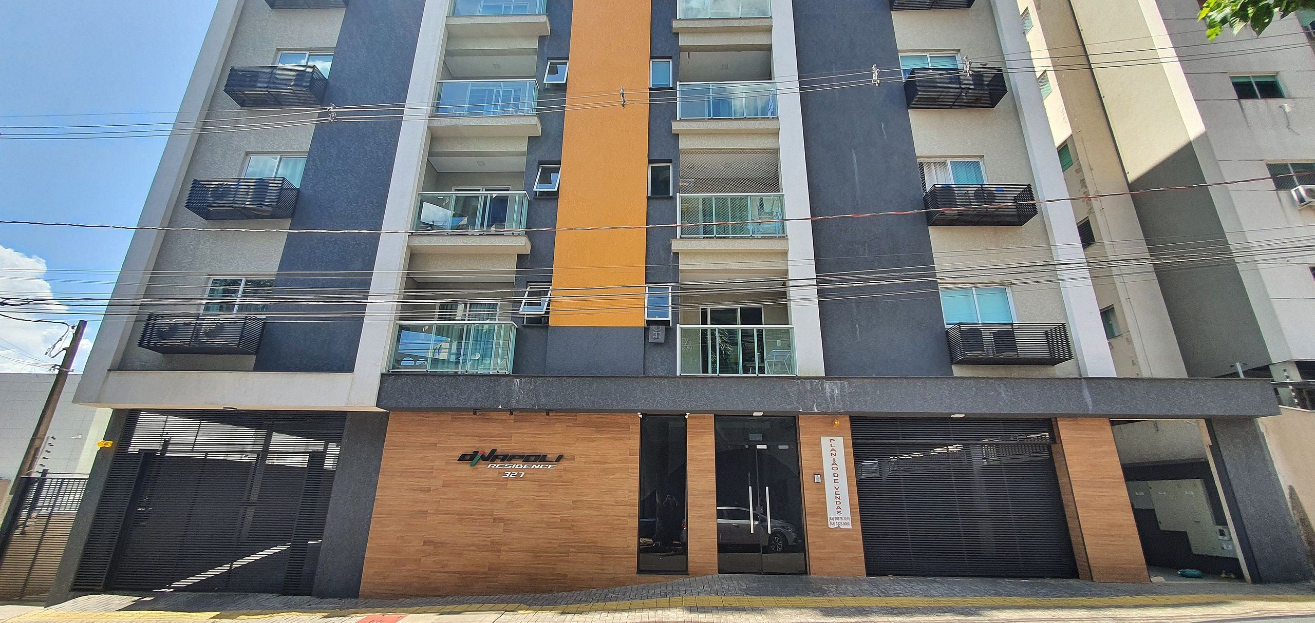 A multi-story residential building with balconies, a wooden facade, and a sign indicating 'RESIDENCE 321'.