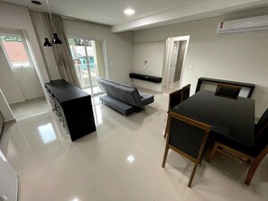 Una cocina moderna con comedor, sofá y horno empotrado.