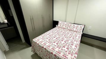 Ein Schlafzimmer mit einem Bett, einem Kleiderschrank und einer kleinen Schreibtischzeile.