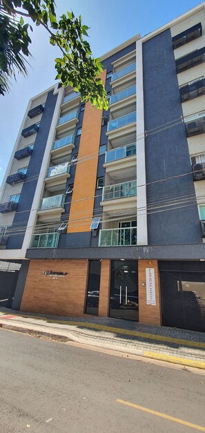 Un hotel de varios pisos con fachada moderna, amplias ventanas y una entrada visible.