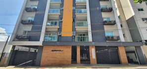 Un edificio residencial de varios pisos con balcones, fachada de madera y un cartel que indica 'RESIDENCE 321'.