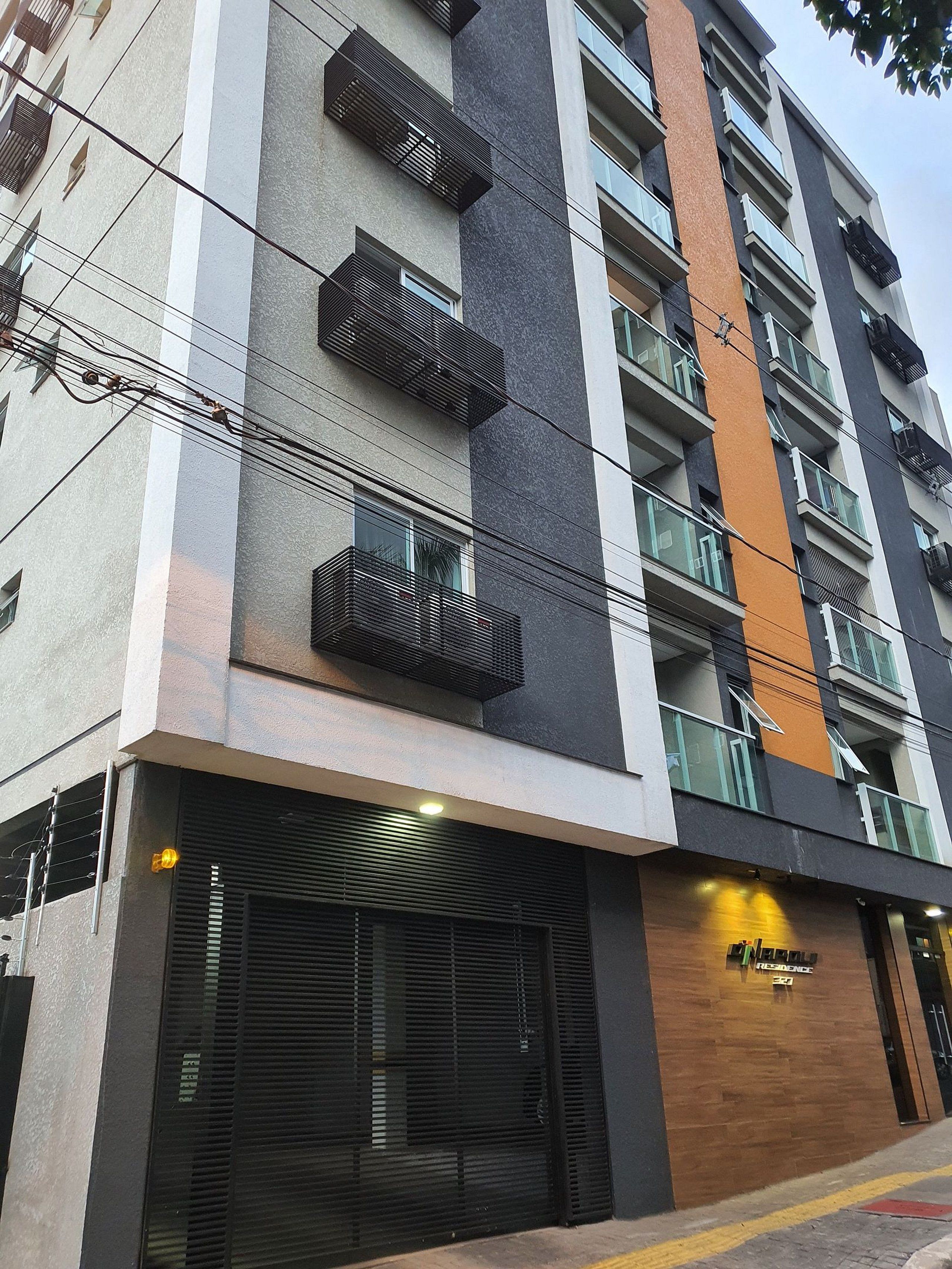 Um hotel com vários andares, varandas, entrada fechada e uma placa com a inscrição 'RESIDENCE'.