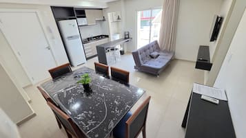 Una cocina moderna con comedor, sofá y televisor.