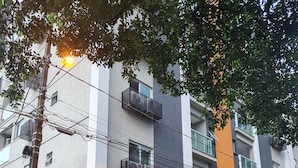 Un edificio de varios pisos con balcones, una entrada de garaje y un cartel que dice 'Hotel Residencia'.