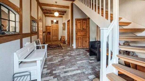 A hallway with a wooden bench, a fireplace, and a staircase. - Nice home in Ljungbyhed with kitchen (Ljungbyhed)