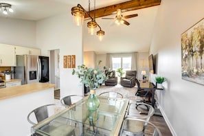 A modern kitchen with a dining area, a ceiling fan, and a large window. - Pet-Friendly Omaha Vacation Rental w/ Deck! (Omaha)