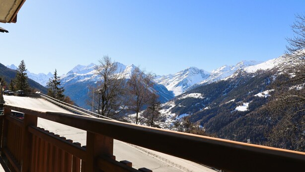 A mountain view from a balcony with a wooden railing. - Outside : Modern apartment  for 5 people, balcony-terrace, beautiful south view, located at tne entr (St-Luc)