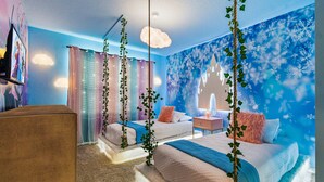 Quarto com duas camas, uma televisão e um mural de um castelo.