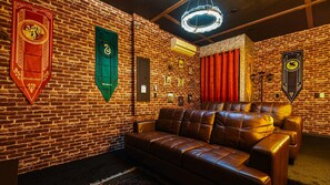 A room with a brick wall, leather sofa, and various wall decorations.