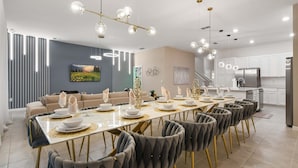 Un comedor moderno con una mesa larga, sillas tapizadas grises y una lámpara de techo contemporánea.