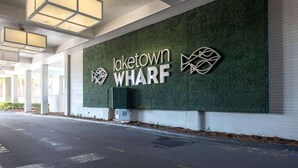 A modern building facade with the text "Laketown WHARF" and a stylized fish logo. - The Beach is Calling at this 13th Floor Beauty (Panama City Beach)