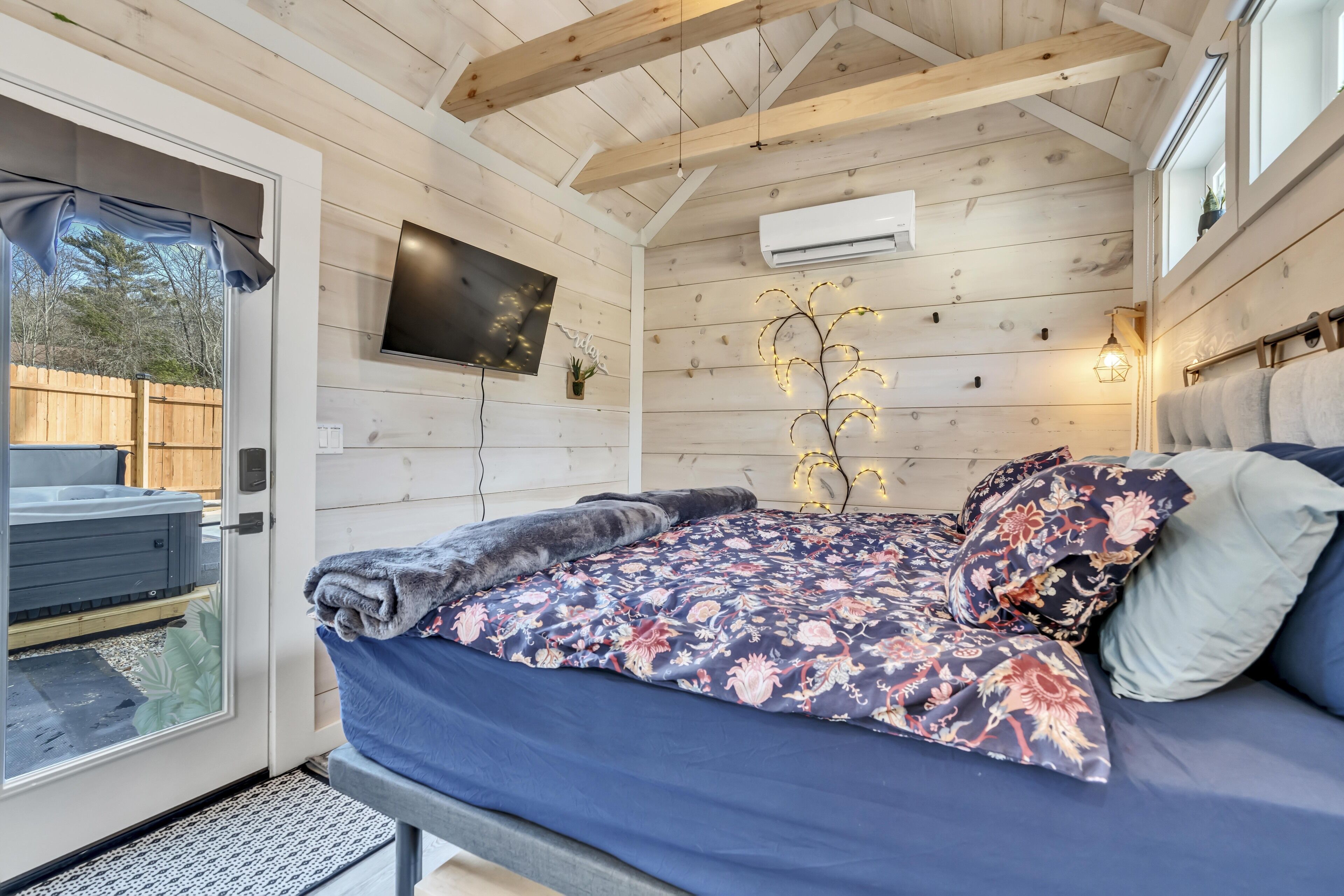 A bedroom with a bed, a TV, and a window.