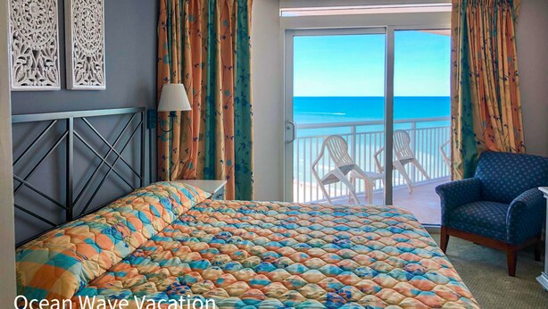 Une chambre avec un lit, une chaise et une vue sur l’océan.