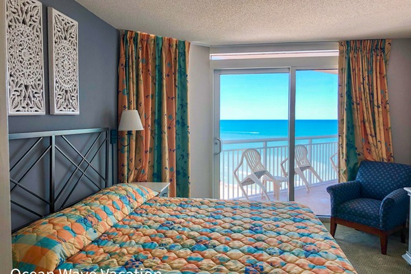 Bright bedroom with ocean view and cozy bedding.