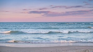 Une plage avec des vagues et un ciel dégagé.