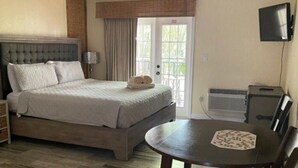 A bedroom with a bed, a table, and a chair. - Dunedin Condo on the Water (Dunedin)