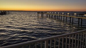 A pier extending into calm waters at sunset. - Dunedin Condo on the Water (Dunedin)