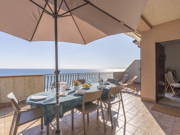 A dining area with a table set for four, overlooking the sea. - Beautiful  villa for 9 people with WIFI, terrace and pets allowed (Andora)