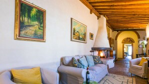 Una sala de estar acogedora con dos sofás, una chimenea y suelo de baldosas.