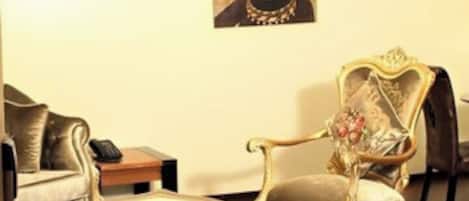 Una sala de estar con un sofá, una mesa de centro, un sillón decorativo y un cuadro en la pared.