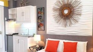 Ein Schlafzimmer mit Bett, Nachttisch, Lampe und Wandbild.