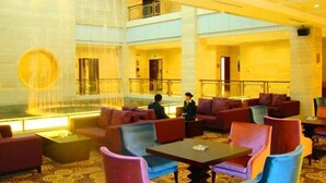 A hotel lobby with a large fountain, multiple seating areas, and a high ceiling. - Yangfang Dadu Hotel (Beijing)